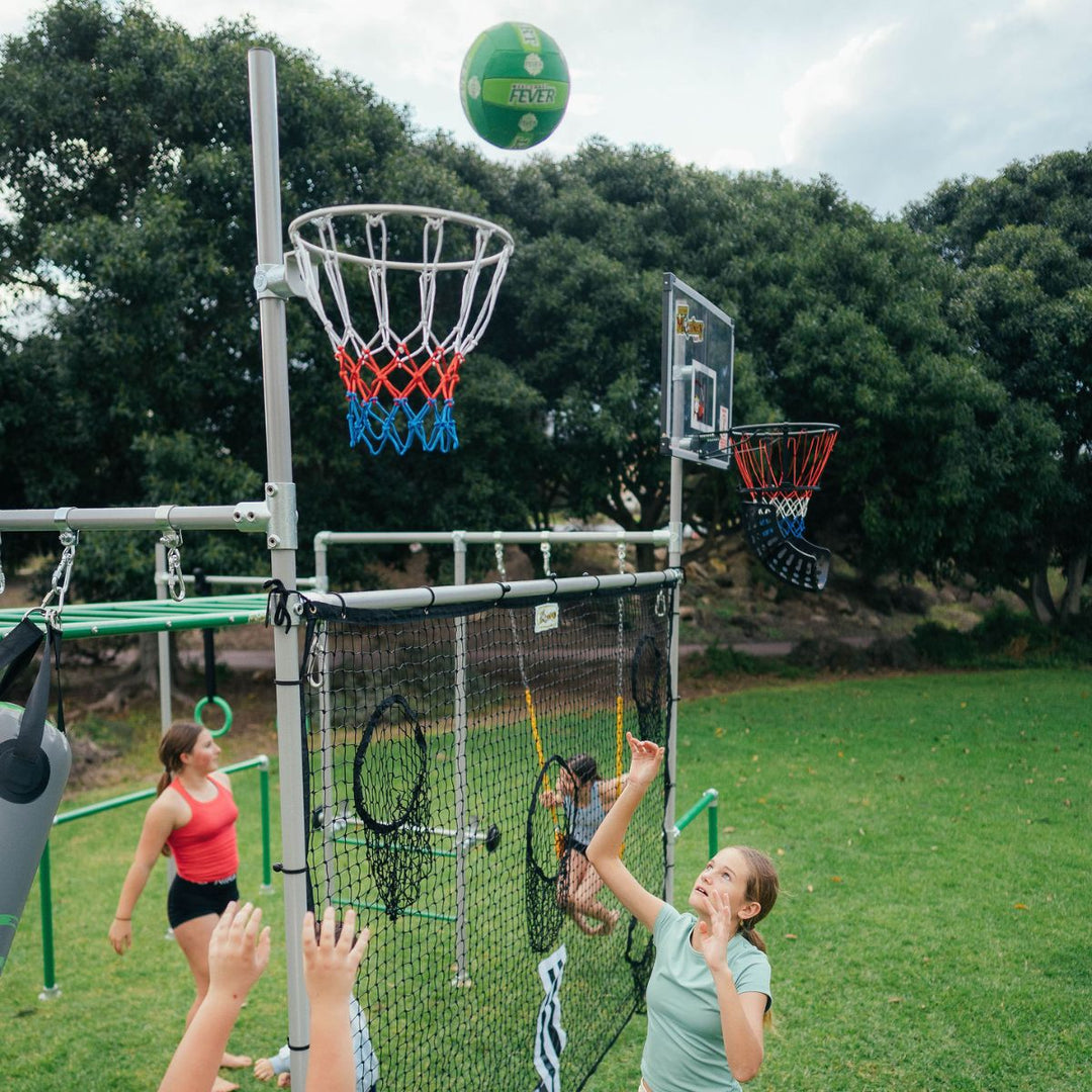 Children playing netball with hoop mounted on a Funky Monkey Bars backyard monkey bar frame