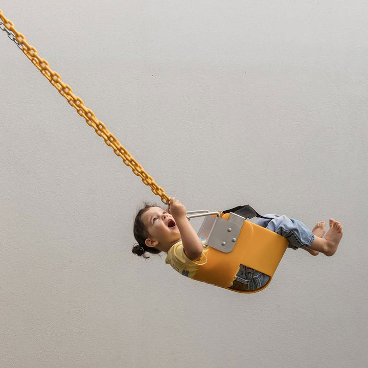 Child riding yellow Funky Monkey Bars Toddler Swing with metal chains and safety strap