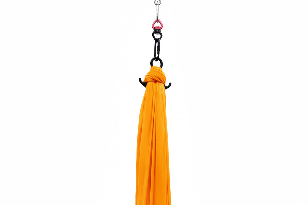 Orange Aerial Silk attached to carabiner and hanging hardware